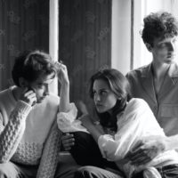 black and white image of two men and a woman sitting together