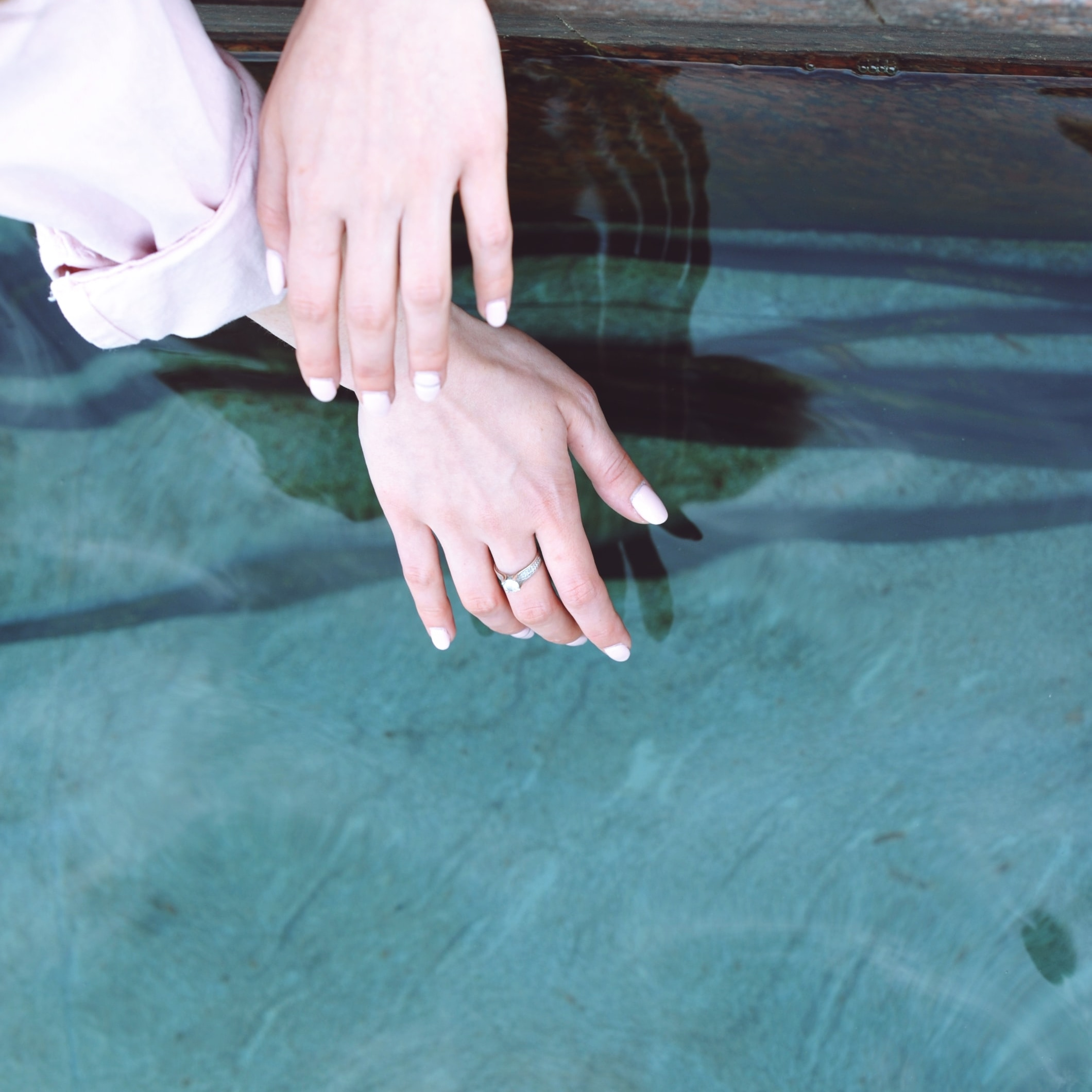 delicate woman's hands draped over water best lube