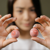 girl holding two tiny balls