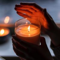 hands holding massage candle in the dark