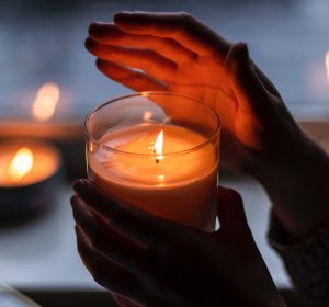 hands holding massage candle in the dark