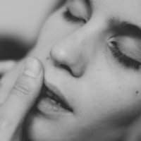 black and white close up of woman sensually touching her cheek