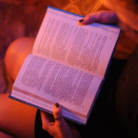 Open book on a woman's lap in red light