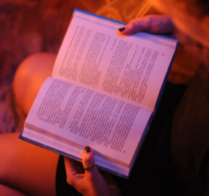 Open book on a woman's lap in red light