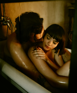 Couple sitting in the bath holding each other