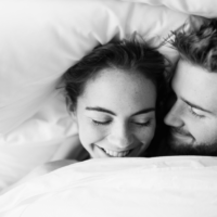 Couple laying in bed, woman smiling