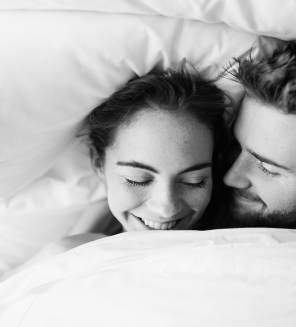 Couple laying in bed, woman smiling
