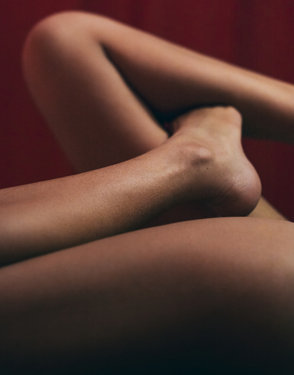 A woman's legs abstractly contorted with a red background.