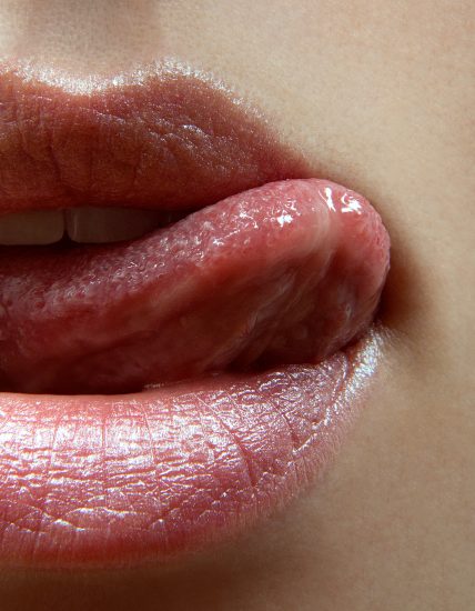 closeup shot of mouth with tongue licking top lip