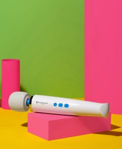magic wand mini on neon pink block on yellow surface with green background and neon pink round shape