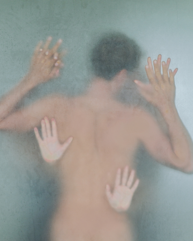 Blurred silhouette of a young naked man in a shower room with two women behind wet frosted glass
