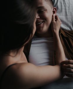 Young attractive couple intimate cuddling in bed