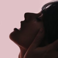 Woman leaning back making a open mouth face from orgasm