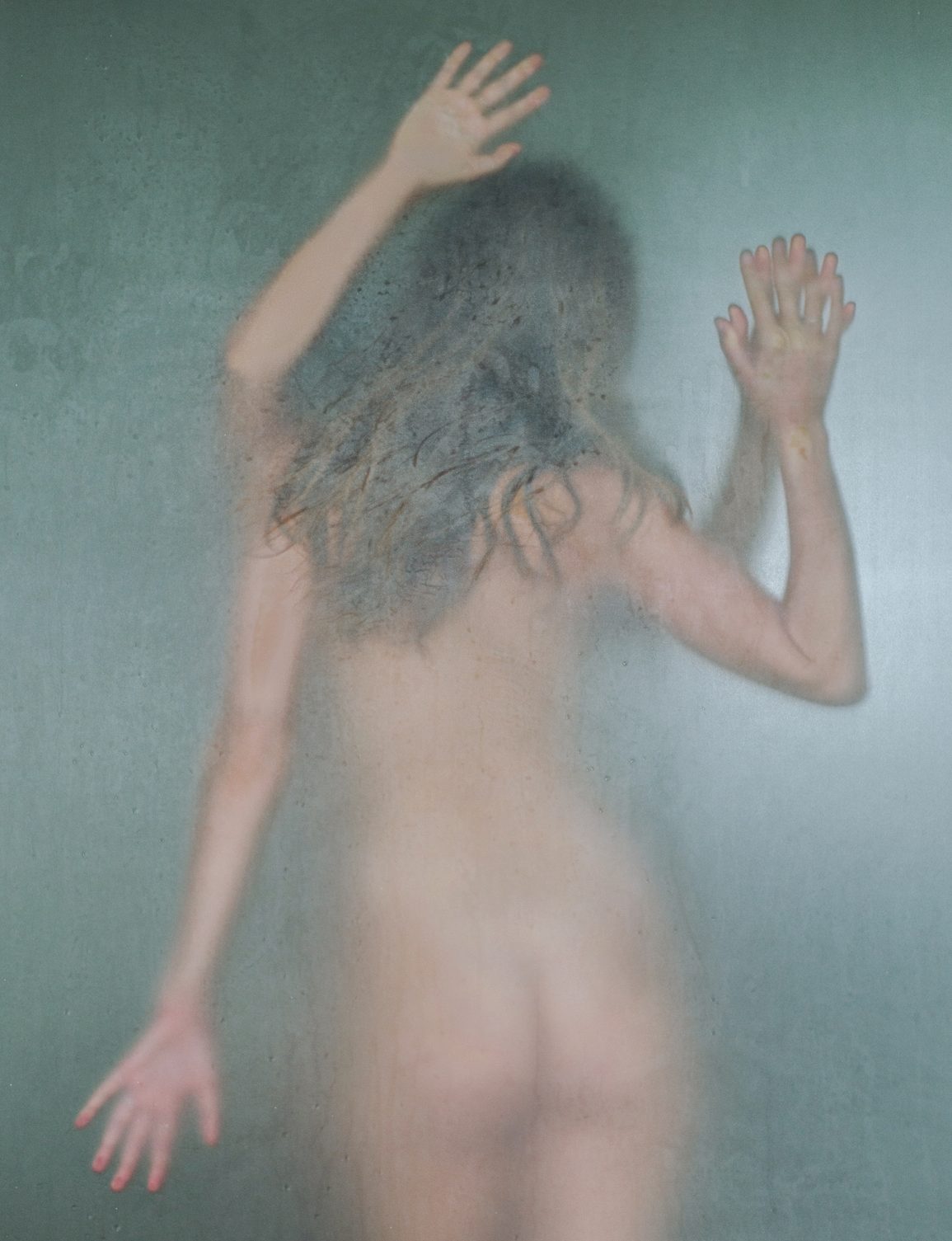 Blurred silhouette of a young naked women in a shower room behind wet frosted glass. Two young woman in bathroom, spa.