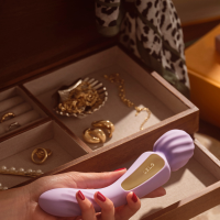 LELO Switch in lavender held in hand above an open jewelry box. Text reads: 'Switch positions. Get 15% off with code EMILY15.