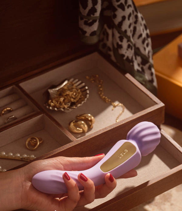 LELO Switch in lavender held in hand above an open jewelry box. Text reads: 'Switch positions. Get 15% off with code EMILY15.