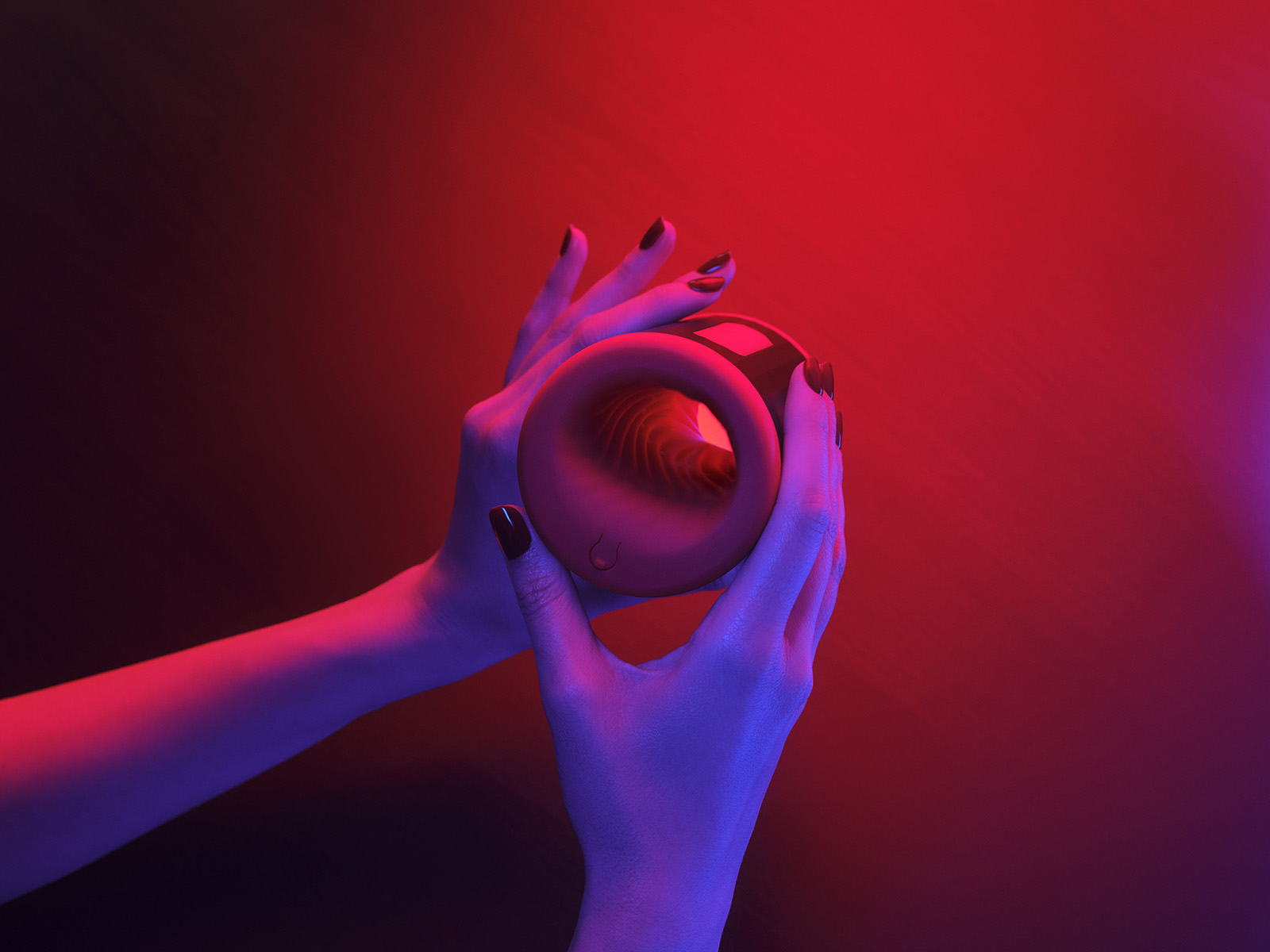 Hands holding the LELO F2S Double Sonic male stroker under red and purple ambient lighting