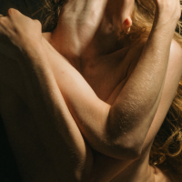 Artistic photo of a woman embracing herself, representing sexual pleasure and exploring blended orgasms